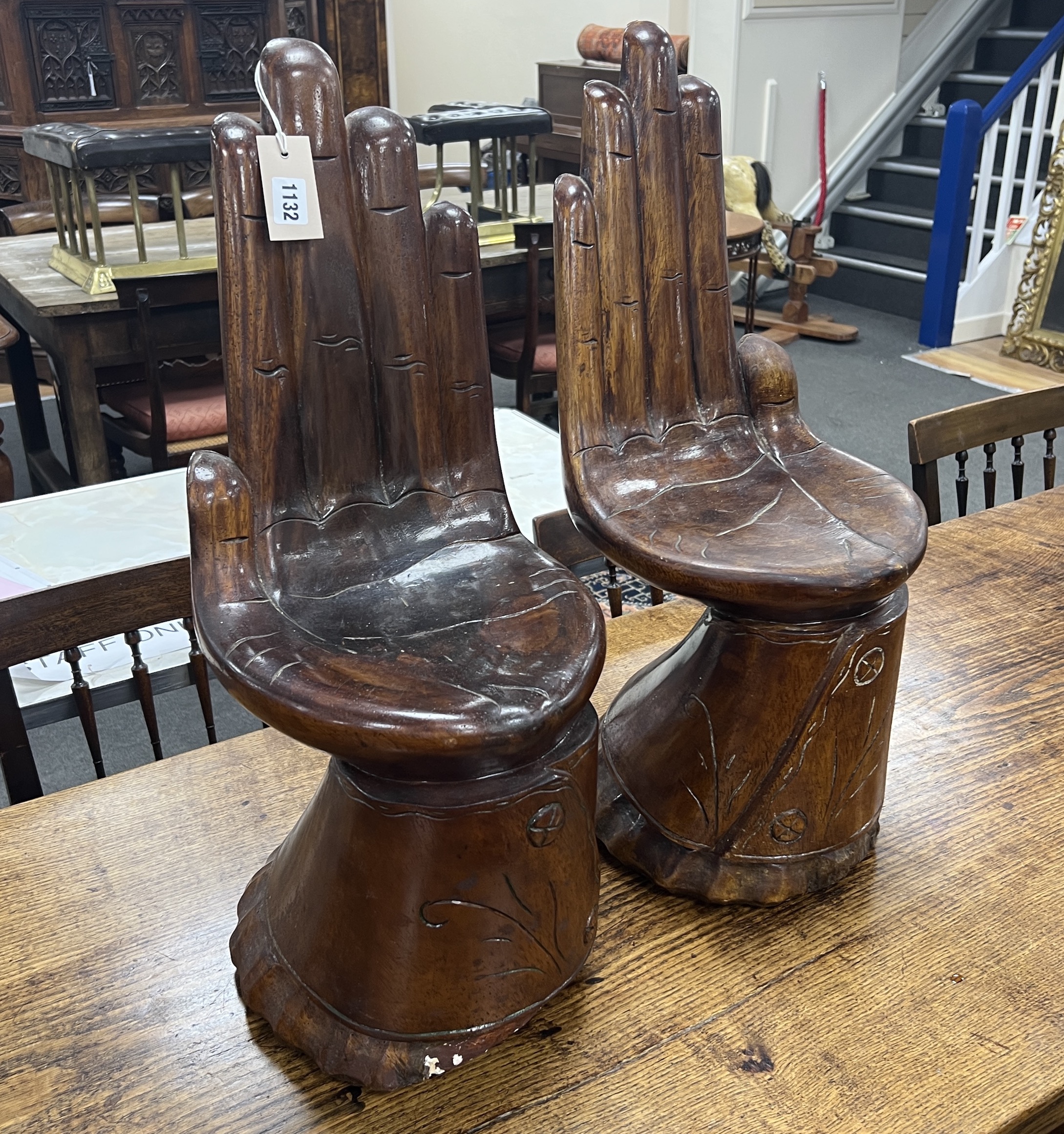 A pair of Eastern carved hardwood stools modelled as hands, height 66cm